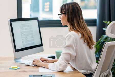 Téléchargez les photos : Prise de vue de jeune femme d'affaires créative travaillant avec l'ordinateur dans une start-up moderne - en image libre de droit