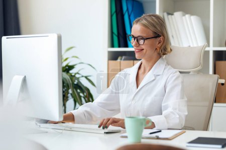 Téléchargez les photos : Prise de vue d'une femme médecin mature travaillant avec un ordinateur lors de la consultation - en image libre de droit