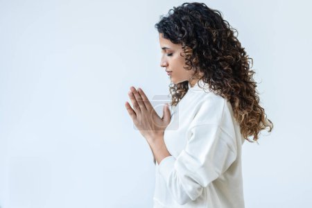 Téléchargez les photos : Prise de vue de zen paisible femme vêtue d'un survêtement blanc faisant des poses de yoga en studio - en image libre de droit