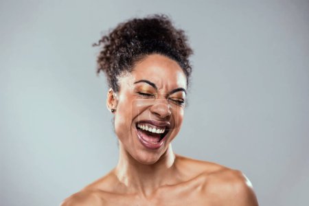 Portrait of beautiful young woman laughing while having fun on isolated white