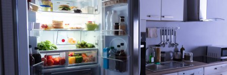 Foto de Nevera abierta en casa. Refrigerador de cocina con comida - Imagen libre de derechos
