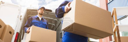 Photo for Blue Truck Delivery Team. Movers Unloading Boxes - Royalty Free Image
