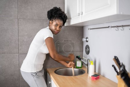 Reinigung verstopfter Spüle und Abfluss in der Küche mit Kolben