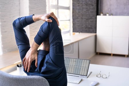 Photo for Employee Stretching At Office Desk At Work - Royalty Free Image