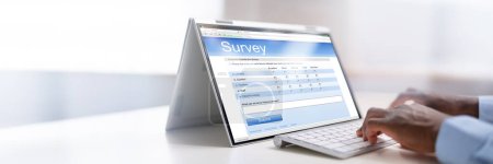 Téléchargez les photos : Formulaire de sondage en ligne rempli par un homme d'affaires sur un ordinateur portable numérique - en image libre de droit