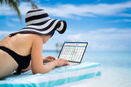 Foto de Data Analyst Woman Using Spreadsheet On Computer (en inglés). Trabajando desde la playa - Imagen libre de derechos
