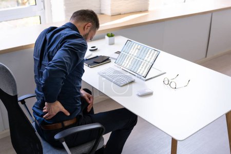 Foto de Hombre con dolor de espalda. Mala postura de oficina - Imagen libre de derechos