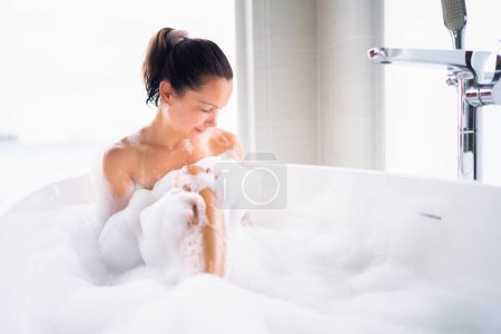 Téléchargez les photos : Belle femme soin du corps Spa dans la salle de bain blanche - en image libre de droit