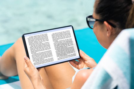 Téléchargez les photos : Femme lecture Ebook sur tablette numérique en vacances - en image libre de droit
