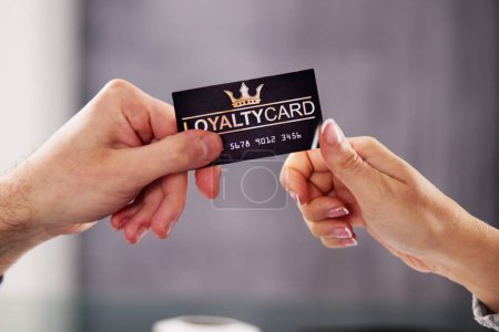 Téléchargez les photos : La main d'un homme d'affaires remettant sa carte de fidélité à son partenaire - en image libre de droit