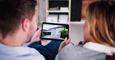 Téléchargez les photos : Couple Famille Recherche immobilier en ligne sur tablette - en image libre de droit