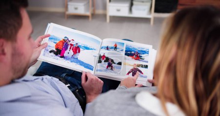 Téléchargez les photos : Couple famille regardant album photo ou livre photo - en image libre de droit