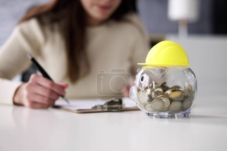 Téléchargez les photos : Piggy Bank With Safety Hard Hat. Construction Budget Save - en image libre de droit