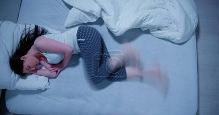 Téléchargez les photos : Woman With RLS - Restless Legs Syndrome. Sleeping In Bed - en image libre de droit