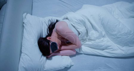 Photo for Close-up Of Beautiful Young Woman Sleeping On Bed With Eye Mask - Royalty Free Image