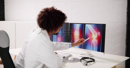 Téléchargez les photos : Examen médical du genou Rayon X sur l'ordinateur - en image libre de droit