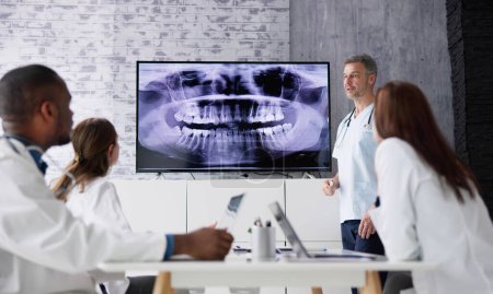 Téléchargez les photos : Dentist Doctors Looking At Teeth Xray Using Computer Software - en image libre de droit