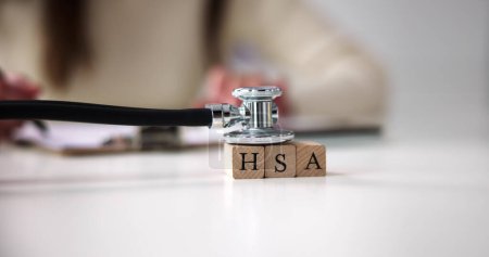 Photo for Hsa Health Savings Account Wooden Blocks Near Stethoscope On Wooden Table - Royalty Free Image