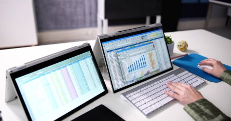 Téléchargez les photos : Businesswoman's Hand Examining Spreadsheet On Laptop In Office - en image libre de droit