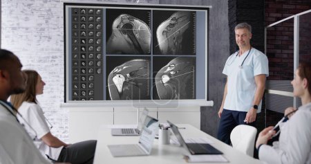 Photo for Physician Doctors Looking At Shoulder MRT Scan - Royalty Free Image