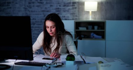 Photo for Accountant Woman In Office At Night With Tax Documents - Royalty Free Image