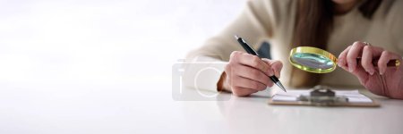 Photo for Tax Audit Document Inspection With Magnifying Glass - Royalty Free Image