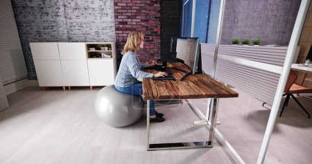 Photo for Correct Posture At Desk In Office Using Fitness Ball - Royalty Free Image