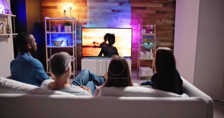 Téléchargez les photos : Couples Watching TV At Night. Television Screen - en image libre de droit