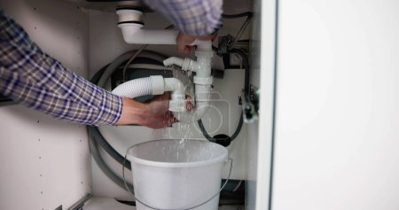 Téléchargez les photos : Plumber Fixing Pipe Leak. Broken Kitchen Sink - en image libre de droit