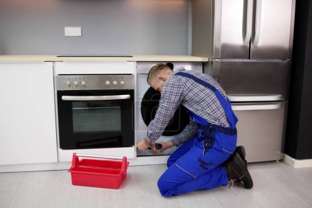 Photo for Carpenter Kitchen Furniture Maintenance Service. Technician Fixing - Royalty Free Image