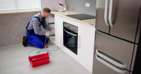 Services de nettoyage de drain de plombier dans la cuisine. Déboucher le tuyau bloqué