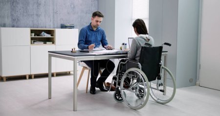 Téléchargez les photos : Femme d'affaires ith handicap assis sur fauteuil roulant dans le bureau - en image libre de droit