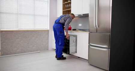 Foto de Técnico de reparación de hornos. Servicio de mantenimiento e instalación de electrodomésticos - Imagen libre de derechos