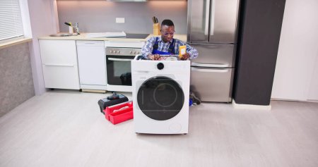 Téléchargez les photos : Réparation et installation de l'appareil de machine à laver dans la cuisine - en image libre de droit