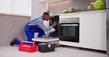 Téléchargez les photos : Afro-américain réparateur réparation lave-vaisselle appareil machine - en image libre de droit