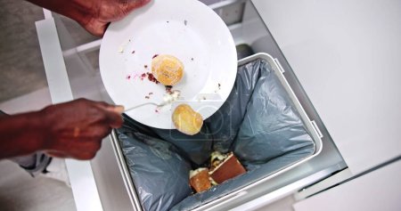 Photo for Throwing Away Leftover Food In Trash Or Garbage Dustbin - Royalty Free Image