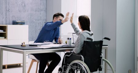 Téléchargez les photos : Femme d'affaires handicapée donnant High Five à son partenaire au bureau - en image libre de droit