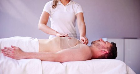 Photo for Man Waxing Chest With Wax Strip In Spa - Royalty Free Image