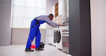 Foto de Hombre joven en general la reparación de la lavadora - Imagen libre de derechos