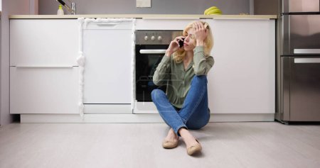 Téléchargez les photos : Appareil de lave-vaisselle cassé Urgence. Femme dans la cuisine - en image libre de droit