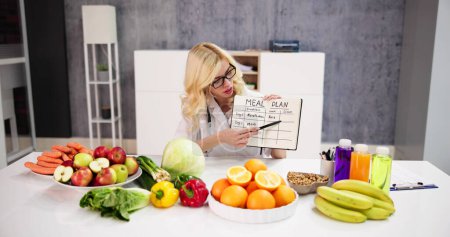 Photo for Dietician Nurse Writing Nutrition Goals And Meals Schedule - Royalty Free Image
