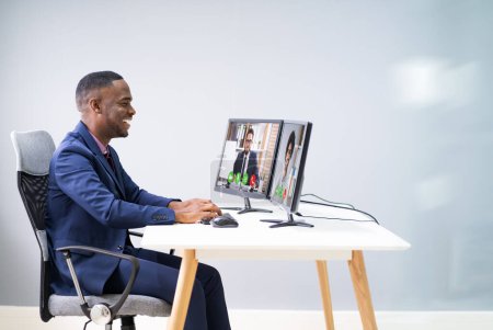 Téléchargez les photos : Jeune homme d'affaires heureux au bureau visioconférence sur ordinateur - en image libre de droit