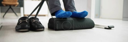 Téléchargez les photos : Homme utilisant repose-pieds pour réduire la fatigue des pieds et des tensions dorsales - en image libre de droit