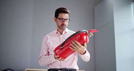 Photo for Fire Extinguisher Check At Home. Reading Expiration Date - Royalty Free Image