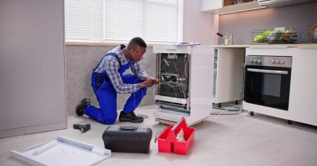 Photo for African Repairman Repairing Dishwasher Appliance. Electrical Check - Royalty Free Image