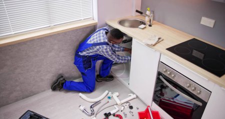 Téléchargez les photos : Nettoyage du plombier Drain et tuyau de cuisine à l'aide d'outils - en image libre de droit