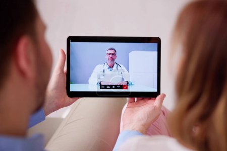 Téléchargez les photos : Couple enceinte en ligne vidéoconférence avec le médecin - en image libre de droit