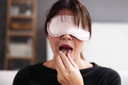 Téléchargez les photos : Goût aveugle. Test alimentaire les yeux bandés. Femme Visage - en image libre de droit