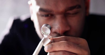 Téléchargez les photos : Bijoutier afro-américain tenant diamant et en utilisant le verre Loupe - en image libre de droit