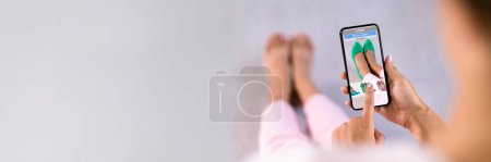Photo for Woman Trying Virtual High Heel Shoes In Shop Or Store AR App - Royalty Free Image
